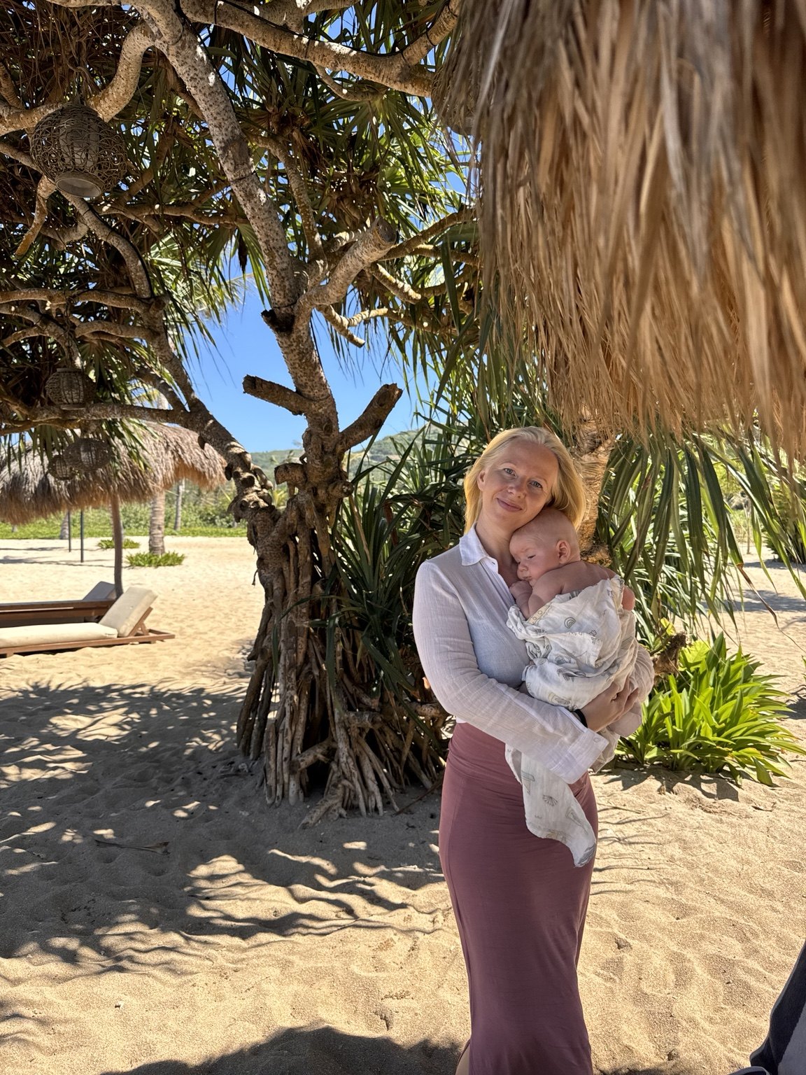 Ellen holding Eros on a sunny tropical beach